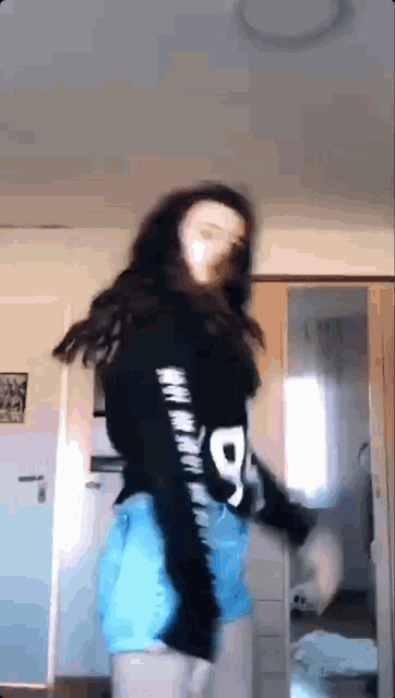 a woman is dancing in front of a mirror in a room .