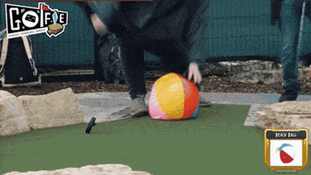 a person playing a game of golf with a beach ball in the background