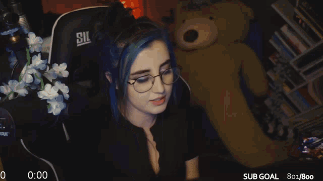 a girl with blue hair and glasses is sitting in front of a teddy bear with a sub goal of 80/800