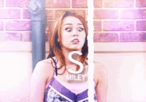 a picture of miley cyrus with the letter s behind her