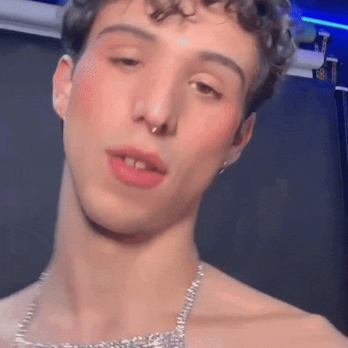 a close up of a man 's face with a necklace around his neck .