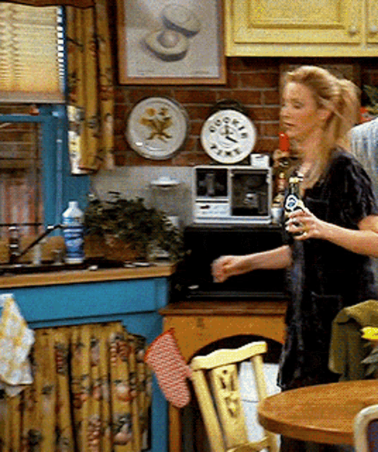 a woman standing in a kitchen with a clock on the wall that shows the time as 4:20