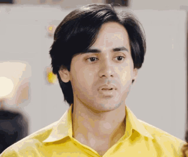 a man in a yellow shirt is looking at something
