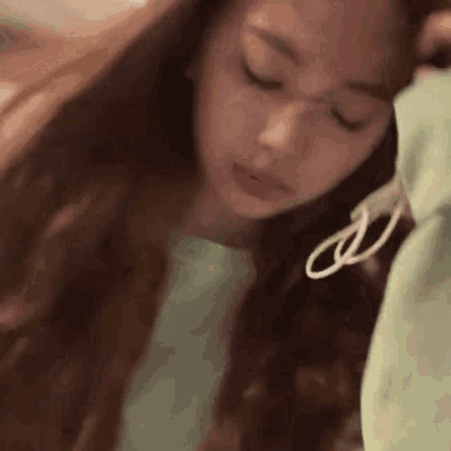 a close up of a woman 's face with her eyes closed and her hair blowing in the wind .