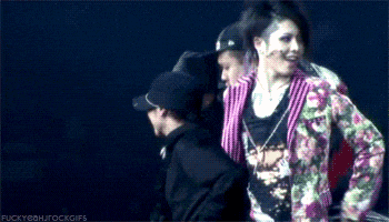 a woman in a floral jacket is standing next to a man in a hat .