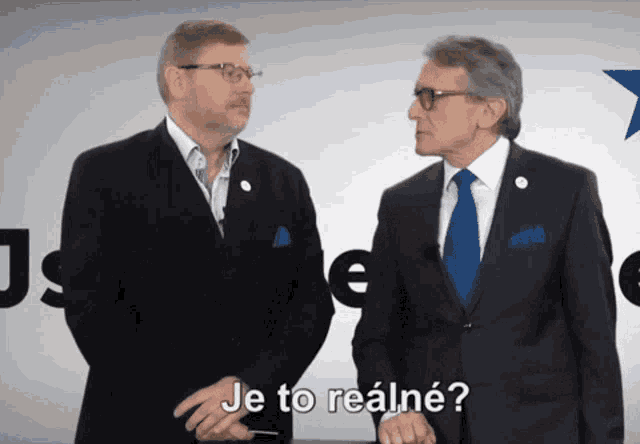two men in suits and ties are standing next to each other with je to realne written above them