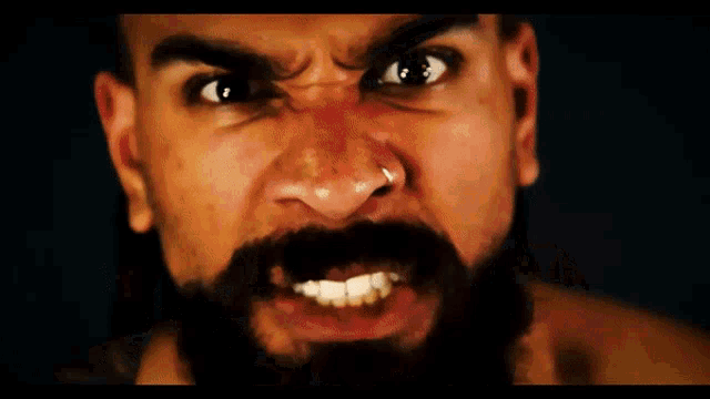 a man with a tattoo on his chest is holding a six man tag team champions belt
