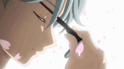 a close up of a person holding a brush with pink petals flying around them