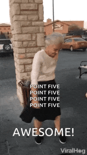an elderly woman is standing in front of a brick wall and holding a trash can .