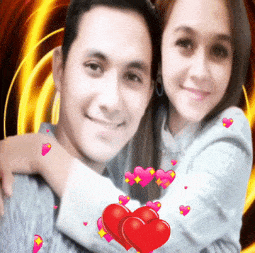 a man and woman are posing for a picture with hearts floating around them