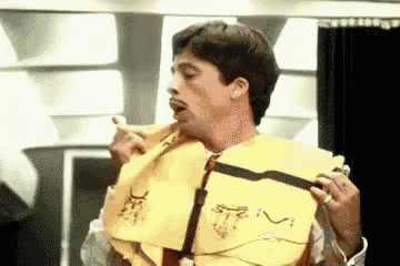 a man is wearing a yellow life jacket with a s on the front