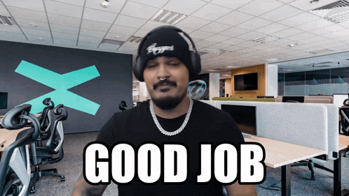 a man wearing headphones and a beanie says " good job "