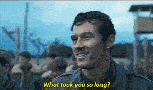 a man in a military uniform is smiling and talking to someone .