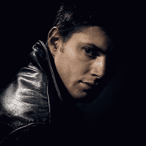 a close up of a man 's face in a leather jacket