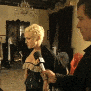 a man is holding a microphone in front of a woman in a black dress .