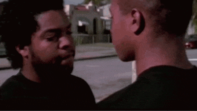 a man is kissing another man 's neck in a street .