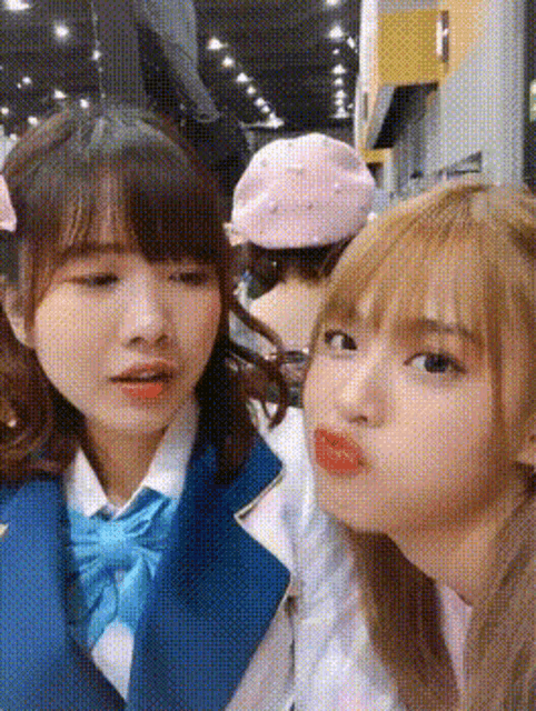 two girls in school uniforms are making funny faces .
