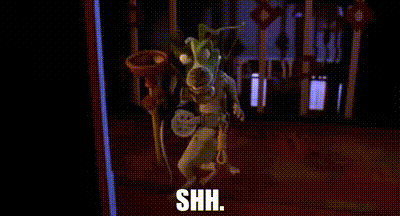 a cartoon character is wearing a mask and holding a trumpet and says shh .
