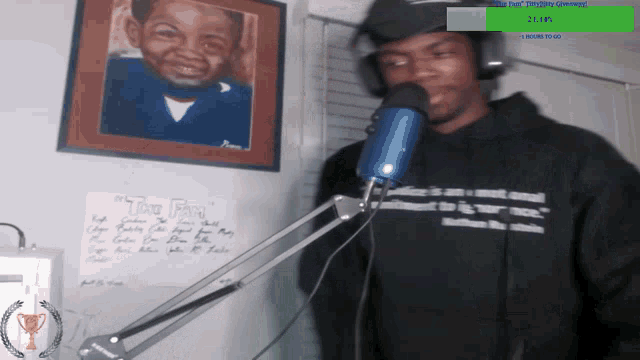 a man stands in front of a microphone with a poster on the wall that says " two fingers "