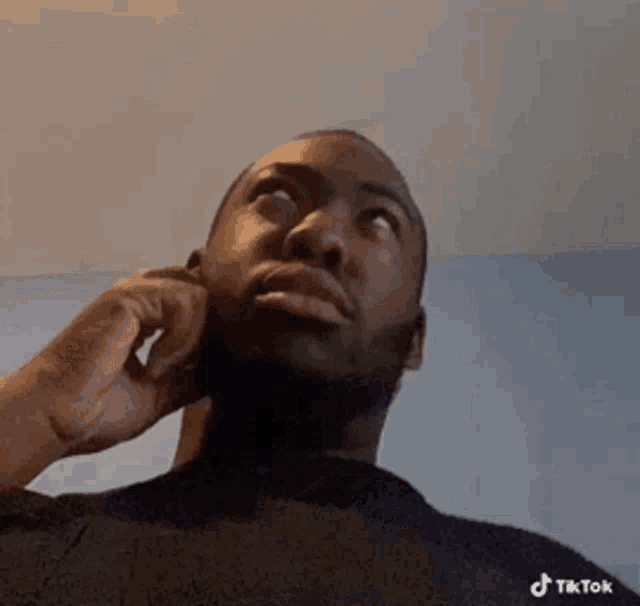 a man is talking on a cell phone while looking up .