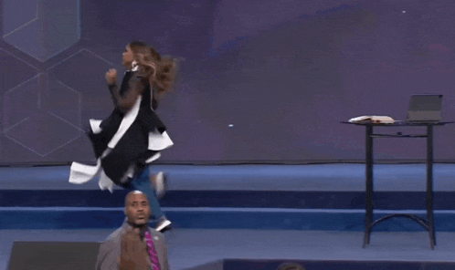 a woman in a black and white kimono is running on a stage