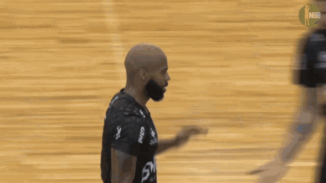 a man with a beard wearing a black shirt that says nbb on it