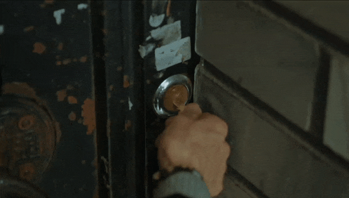 a close up of a person 's hand opening a door with a sticker on it that says ' a ' on it