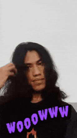 a man with long hair is wearing a purple shirt that says wooowww