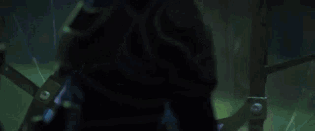 a young girl with blue hair and a blue shirt is standing in a dark room .