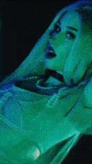 a close up of a woman 's face with green lights behind her .