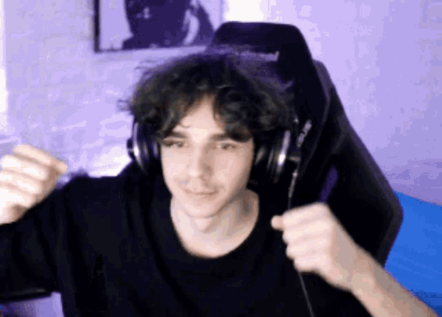 a man wearing headphones and a black shirt is sitting in a chair