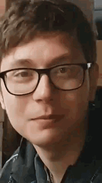 a close up of a man wearing glasses making a funny face .