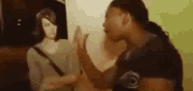 a woman is giving a high five to another woman while standing in front of a painting .