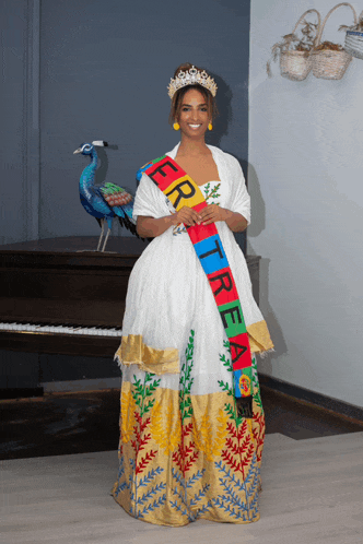a woman in a white dress has a sash that says eritrea on it