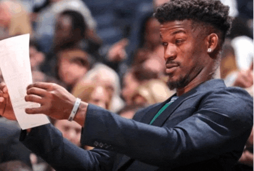 a man in a suit looks at a piece of paper