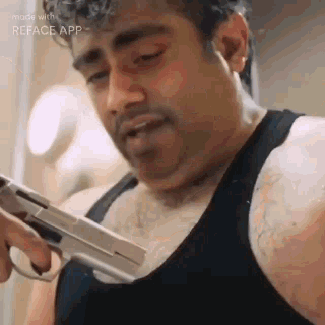 a man with a beard is holding a gun in his hand .