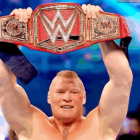 a man is holding up a wrestling championship belt .