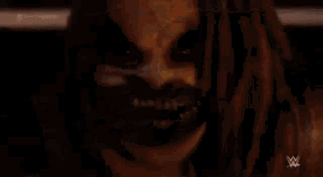 a close up of a person wearing a scary mask with dreadlocks and a big smile .