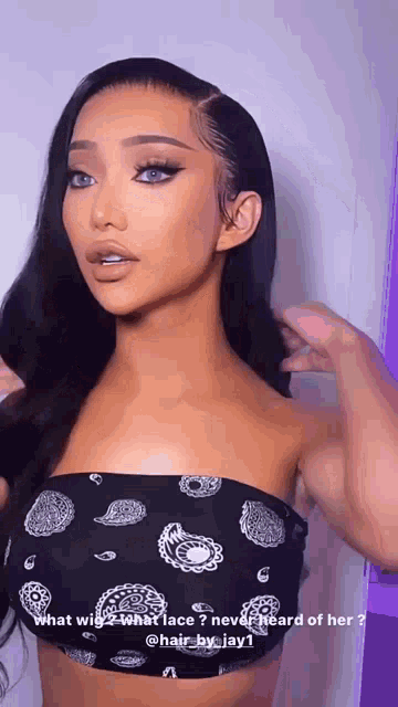 a woman is wearing a bandana and a black top with paisley on it