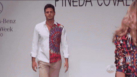 a man is walking down a runway wearing a shirt that says pineda coval