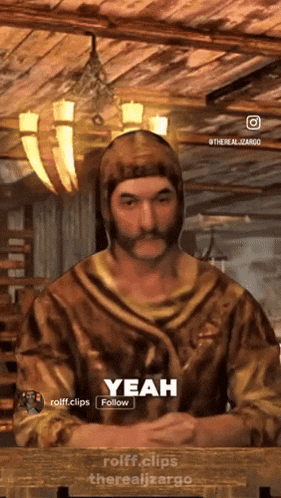 a man with a beard is sitting at a table and says yeah follow