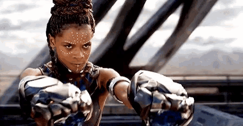 a woman with braids is wearing boxing gloves and a bun .
