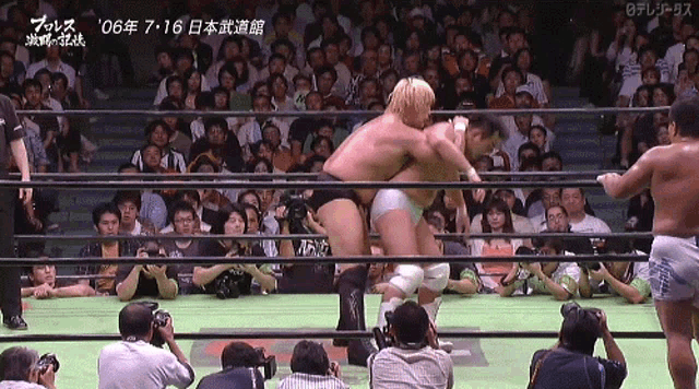 two men in a wrestling ring with a crowd watching and a sign that says ' 2006 ' on it