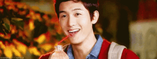 a young man is drinking water through a straw .