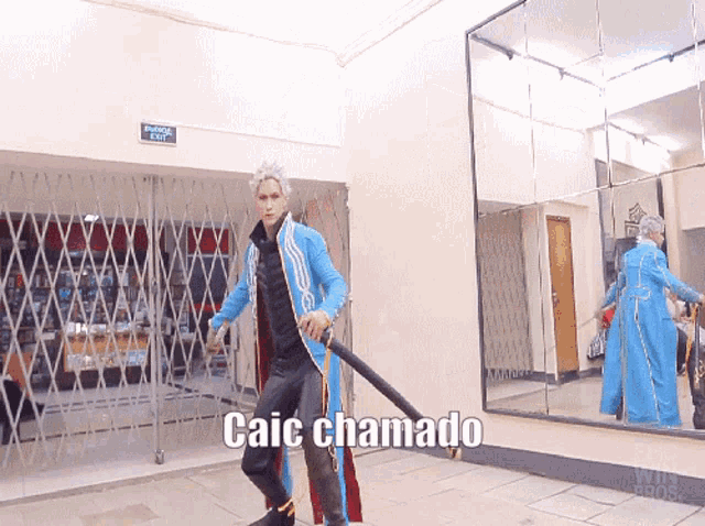 a man in a blue jacket is holding a sword and the words caic chamado are on the floor