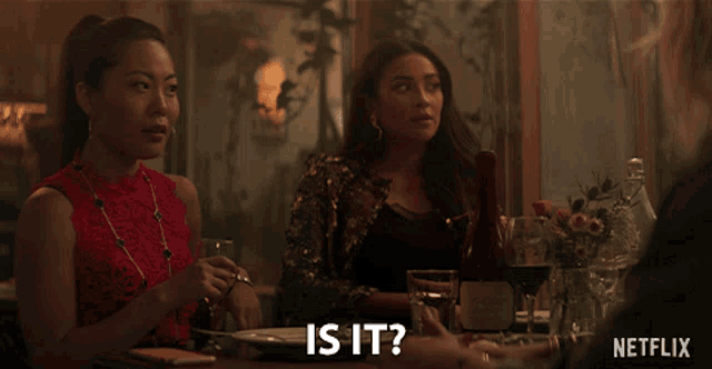 two women sitting at a table with a bottle of wine and a netflix logo