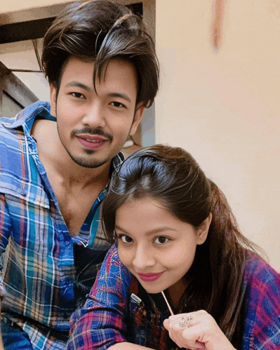 a man and a girl posing for a picture with the girl holding a lollipop