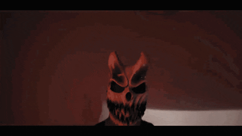 a person wearing a skull mask with horns and sharp teeth