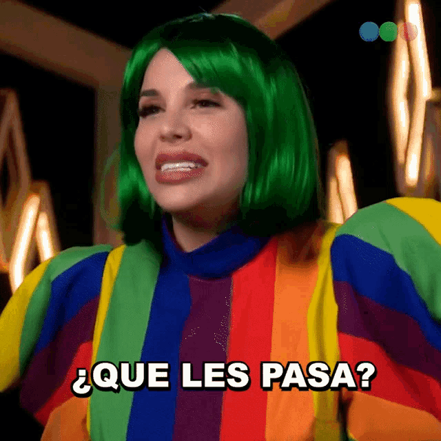 a woman with green hair is wearing a rainbow sweater and says " que les pasa "