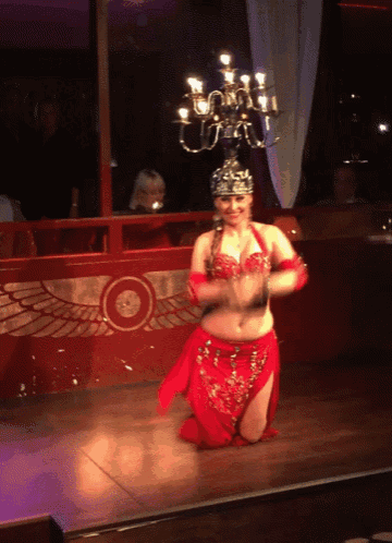 a belly dancer is kneeling down on the floor